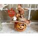 This image shows a Halloween witch decoration. It is made from a real dried gourd. Her name is Beatrice and has an orange witch hat.